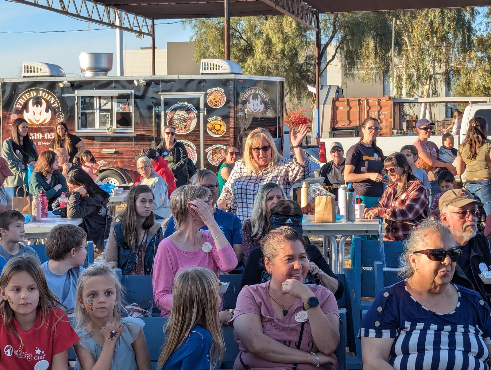 Families seated in front of the food trucks at a past St. Philip Neri Festival.